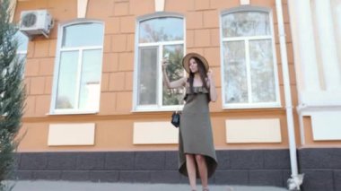 Bir şapka ve uzun elbise genç bir kadın ve bir selfie yapar ona telefon türleri