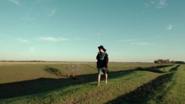 Mutlu kız şapkalı ve yalınayak bozkır ortasında sonbahar güneşli günde çalışır..