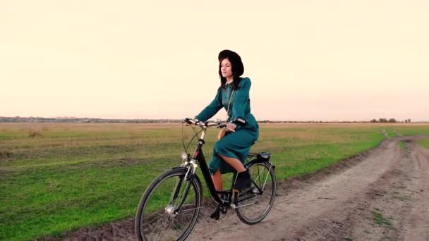 Jong meisje in een hoed en met een fiets in de steppe. — Stockvideo
