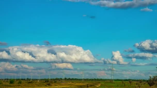 草原で高圧電線。高速は時間経過で雲を移動します。高圧鉄塔の空の背景 — ストック動画