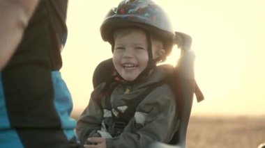 Eski bir kask ve bir çocuk bisiklet koltuğu 2-3 yaşında bir çocuk. Dawn. Aile bisiklet yürüyüş.