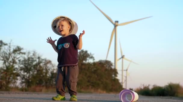 Un ragazzino gioca con il casco da costruttore. Se lo mette e salta finché non cade. — Video Stock