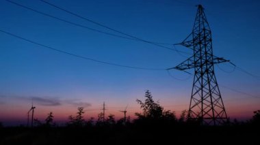 Güneş son ışınları karşı duran bir güç kulesi silueti