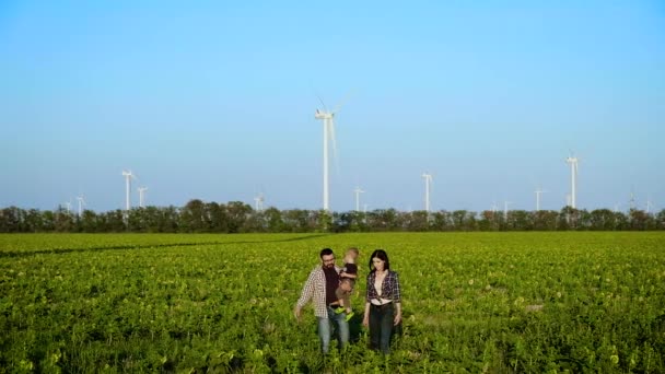 Une famille heureuse marche à travers le champ. Un homme porte son fils. Mouvement lent 