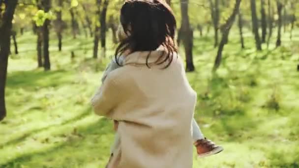 Молодая мама со своим маленьким мальчиком развлекается в осеннем парке — стоковое видео