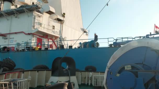 Эвакуация кораблей в море. Морской буксир приближается к грузовому судну для буксировки. Человек в шлеме на палубе корабля . — стоковое видео