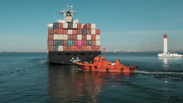 Odessa, Ucrânia, porto marítimo. 20 de outubro de 2018. Barco piloto laranja escolta um grande navio mercante para o mar aberto — Vídeo de Stock