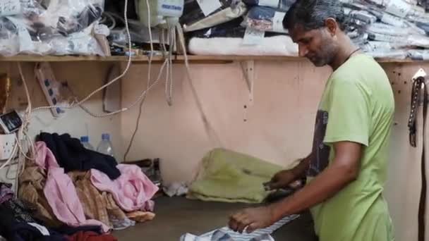 Opalony mężczyzna żelazka koszula z elektrycznym żelaza w ulica warsztat — Wideo stockowe