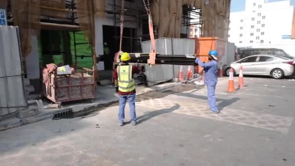 Straat gebouw gebied werknemers help kraan lift metalen balk — Stockvideo