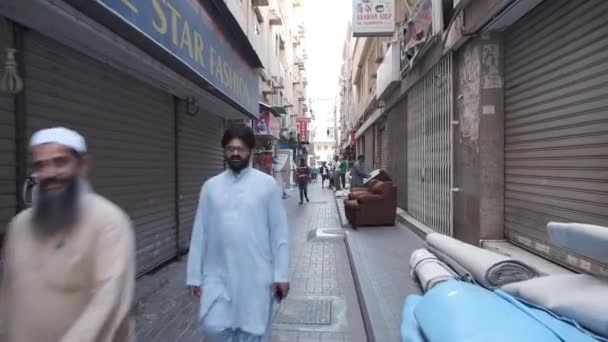 Männer gehen durch Fußgängerzone mit offenen und geschlossenen Geschäften — Stockvideo