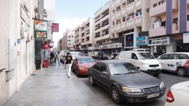 Las calles del viejo Dubai: en la acera un montón de coches aparcados, transeúntes van en la acera. Barrio residencial . — Vídeo de stock