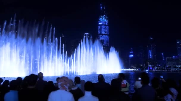 Silhouette turistiche guardare fontane luminose di notte a Dubai — Video Stock