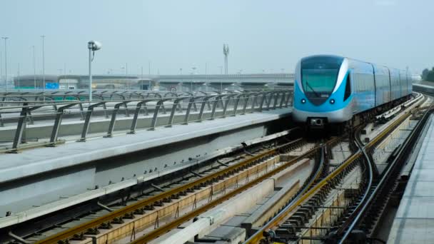 Dubai Metro Trein gaat langs het spoor tegen de achtergrond van engineering en spoorweg structuren — Stockvideo