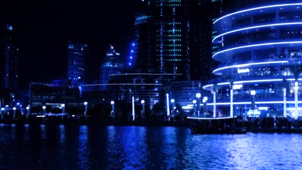 Un'illuminazione musicale deliziosa della torre più alta del mondo - Burj Khalifa. Il lago artificiale della fontana danzante, barche da diporto e turisti sul molo vicino al Dubai Mall — Video Stock