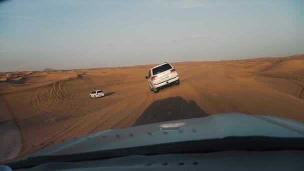 Jeep Safari no deserto árabe. Vista de carro em jipes dirigindo entre trilhas do deserto ao pôr do sol — Vídeo de Stock