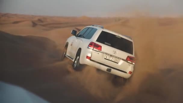 Jeep Safari en el desierto árabe. Vista del coche en jeeps conduciendo entre pistas del desierto al atardecer — Vídeo de stock