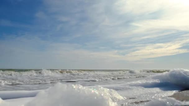 Морська піна, яка утворилася від бризок хвиль на порожньому піщаному зимовому пляжі. крупним планом морська піна — стокове відео