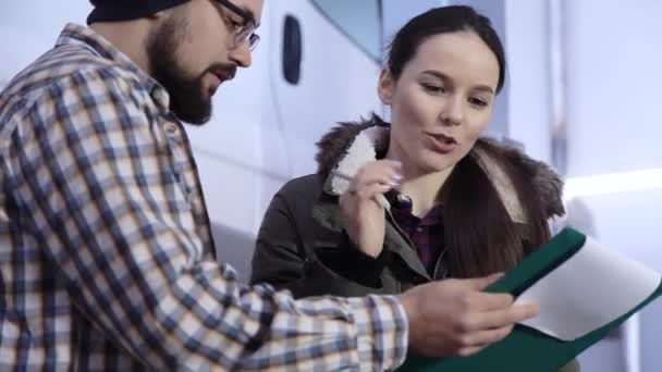 Mujer cliente y mecánico automático con libro de servicio cerca de la máquina en la estación de servicio — Vídeos de Stock