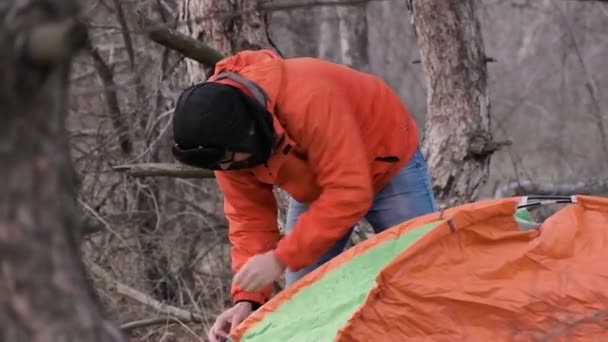 Um turista solitário que viaja pela floresta de pinheiros monta uma tenda para a noite — Vídeo de Stock