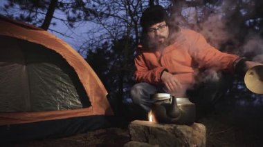 Gece ormanda bir turist çadırın yakınında yangın çıkardım ve bir su ısıtıcısı ateşe. Adam su içinde kaynıyor öğrenmek için su ısıtıcısı kapağını kaldırır.