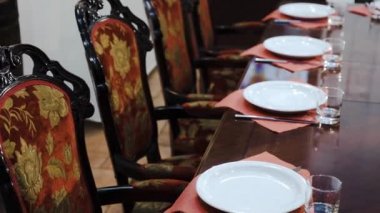 Lüks mobilya: kırmızı kumaş döşeme, büyük cilalı yemek masası, yemek takımı - prestijli bir restoran ile yumuşak sandalyeler