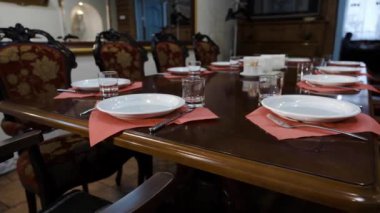 Prestijli bir restoranda sofra. Derin tabak ve cam kadehler, çatal şık cilalı ahşap bir masa prestijli bir restoranın üzerinde.