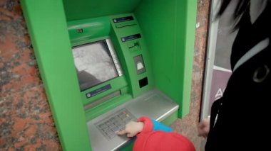 Bir Atm kullanmak için bir çocuk anne öğretir