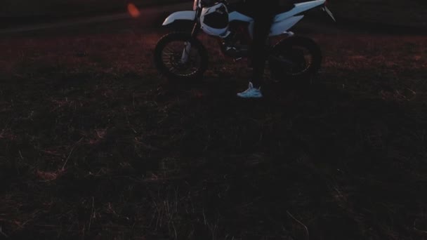 Chica joven en una motocicleta observa el atardecer — Vídeos de Stock