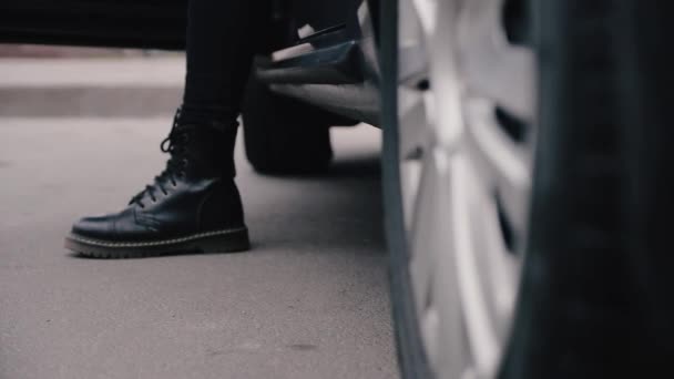Stivali di tipo militare sulle gambe femminili quando si atterra in macchina . — Video Stock