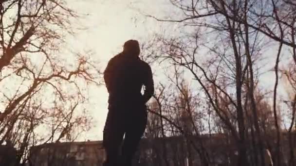 A young girl runs through the park with a sports bottle in hand — Stock Video