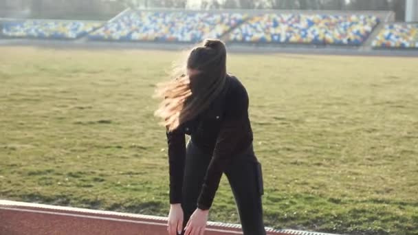 Slim ung jente varmer opp på stadion – stockvideo