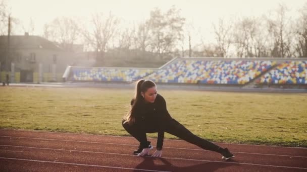 A menina está envolvida na aptidão no estádio . — Vídeo de Stock