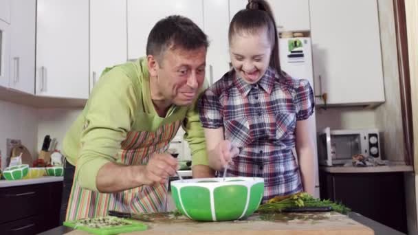 Girl with down syndrome and father mix dough ingredients — Stock Video