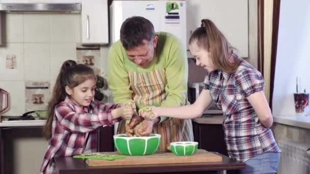 Девушка с синдромом Дауна и сестра месить толстые тесто — стоковое видео