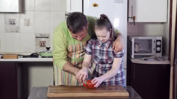 Отец помогает дочери с синдромом Дауна резать перец — стоковое видео
