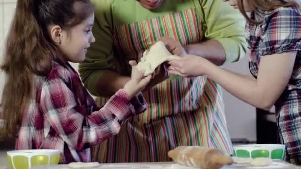 Family plays with dough stretching piece above table — Stock Video
