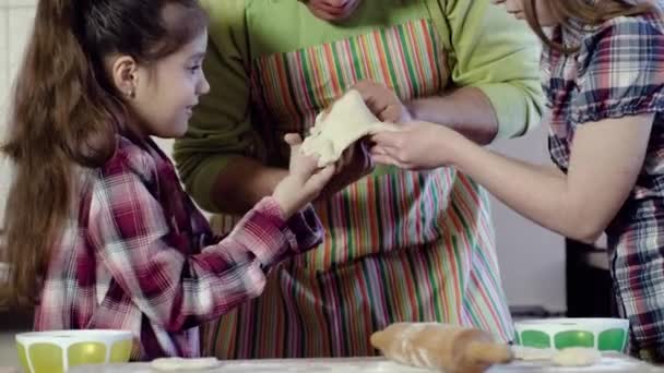 Familia juega con la masa estiramiento pieza por encima de la mesa — Vídeos de Stock