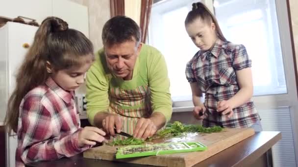 Otec ukazuje pozorné dcery stříhací zelené na palubě — Stock video