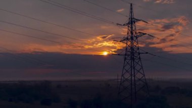 Zaman aralığı. Elektrik hatlarının arka planında gün doğumu.