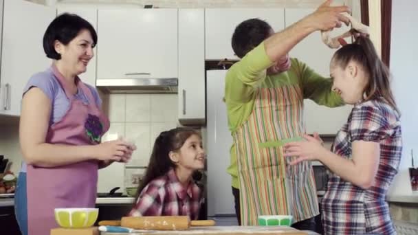 Padre bromea con su familia en la cocina mientras cocina comida de la masa . — Vídeos de Stock