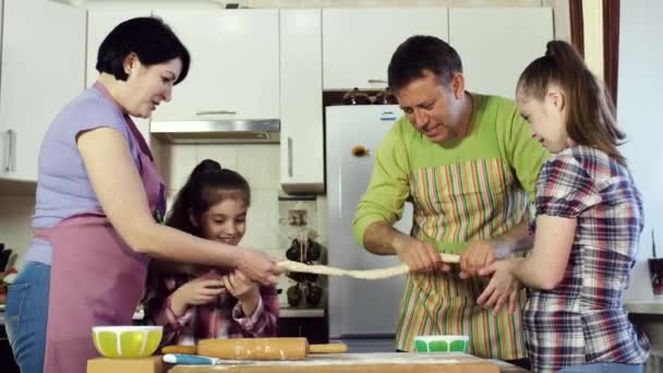 Famille amicale et drôle ensemble et amusant dérouler la pâte . — Video