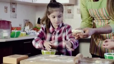 aile masa nın üzerinde hamur germe parçası ile oynar