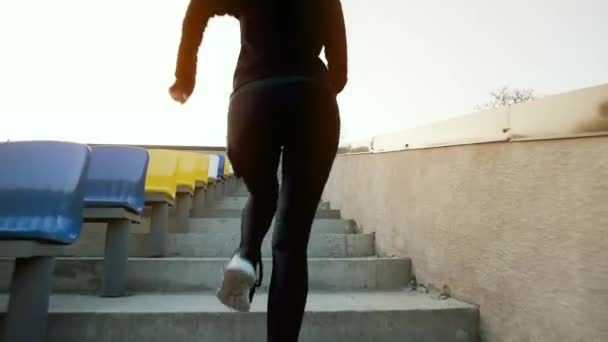 Meisje atleet loopt snel de trap van het stadion. — Stockvideo