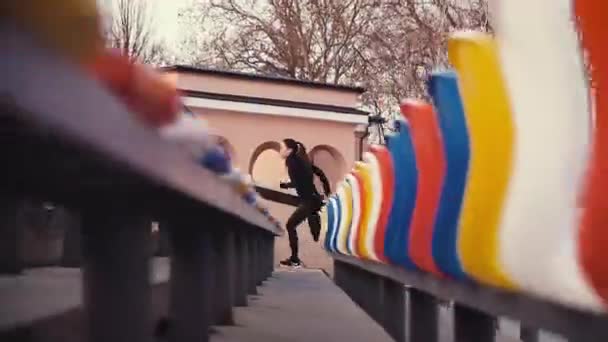 La chica-atleta corre rápidamente cerca de los asientos del espectador en el estadio . — Vídeo de stock