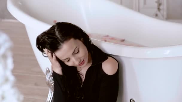 Сексуальная девушка сидит на полу в ванной и истерически смеется. . — стоковое видео