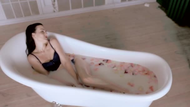 Сексуальна дівчина з задоволенням приймає ванну з молоком, верхній кут . — стокове відео