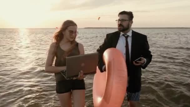 Jefe con una secretaria en traje y sin pantalones, en la rodilla en el agua . — Vídeos de Stock