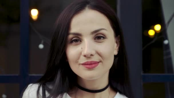 Retrato de una chica alegre con los ojos abiertos. Una mujer joven mira en la lente de la cámara . — Vídeos de Stock