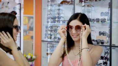 Üç kız arkadaş güneş gözlüğü elde sevinirler.