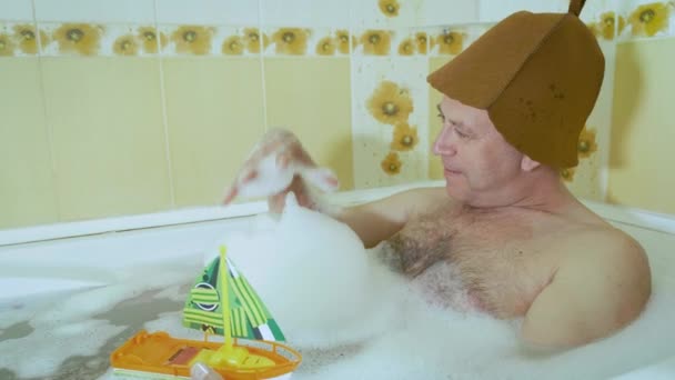 Középkorú férfi a fürdőszobában játszó baba csónak — Stock videók